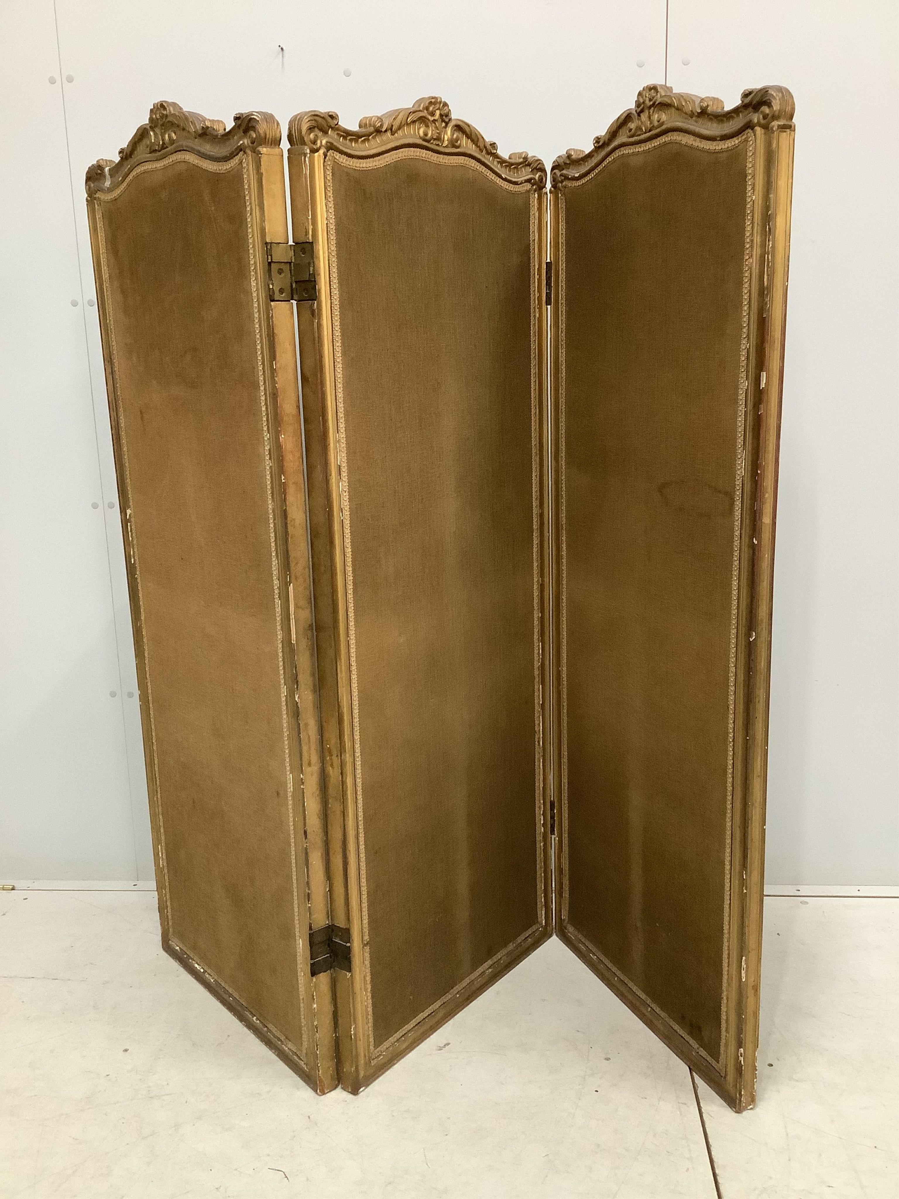 A Victorian style folding giltwood and composition three fold dressing screen, each panel width 62cm, height 162cm. Condition - fair